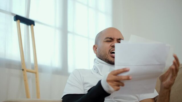 UnHappy man stressed pay invoice medical expenses from accident fracture broken bone injury with leg splints in cast, neck splints collar, sling support arm. Social security and health insurance.