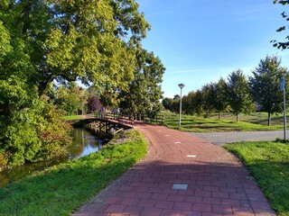 Red cycle lane in the park leading to a bridge