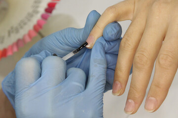 
Workplace of a manicure master. A salon specialist performs work with a client.
Nail technician...