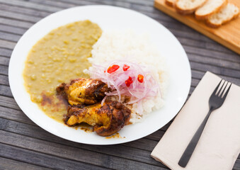 Peruvian dish. chicken wings with pea puree, rice and pickled onions