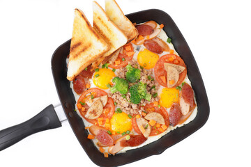Fast food breakfast, fried eggs in pan and vegetables, top view.