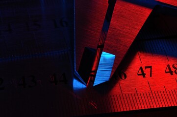 caliper and metal rulers illuminated in red and blue. close-up