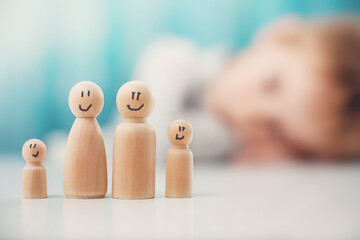 Wooden figures of the family standing on the table.