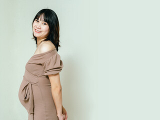 Obraz premium Pregnant happy woman touching her belly with a happy face, Caressing her belly and smiling, Healthy Pregnancy concept on white background, Copy space.
