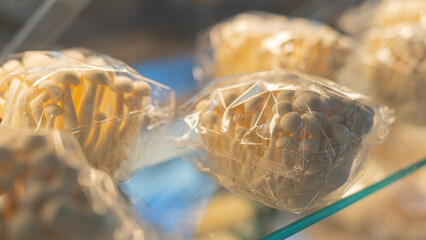 Market stall with fresh shimeji mushrooms in plastic boxes. farmers local market