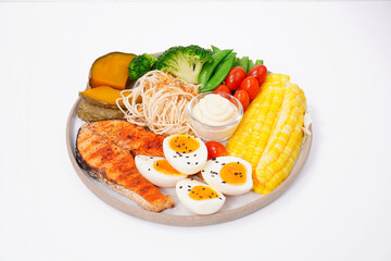 Healthy food, cooked salmon, boiled chicken eggs, broccoli, poached vegetables, white background