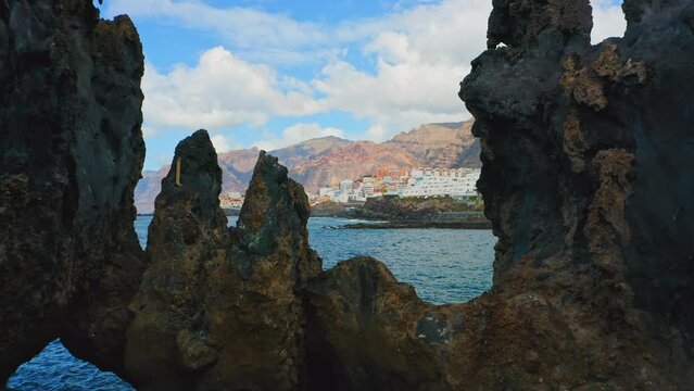 Natural swimming pool of Devil. Aerial flight walk through dangerous rocks. Frozen black lava flows, volcanic bizzare stones, rocky beach, Atlantic Ocean. Tenerife, Canary Island, Charco El Diablo.