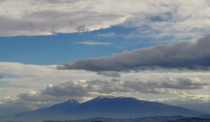 Obraz na płótnie Canvas Nuvole bianche sopra i monti Appennini in una giornata di sole invernale