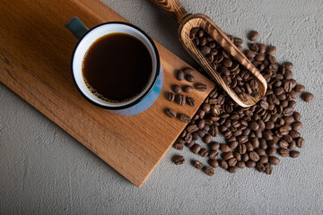 Blue cup of coffee with roasted coffee beans
