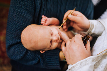 The priest in the church conducts a sacred rite, the ritual of anointing the head of a newborn...