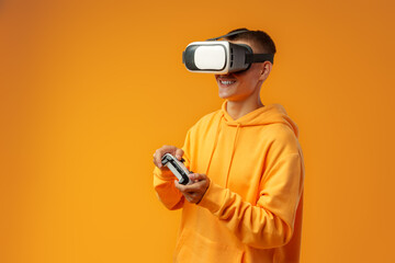 Young man using virtual reality headset against yellow background