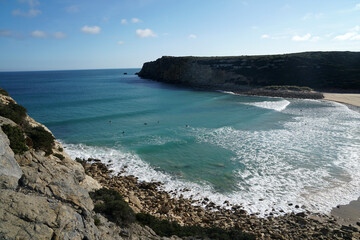 Surfers waiting for waves on praia Ingrina near Sagres in Portugal, Algarve                               
