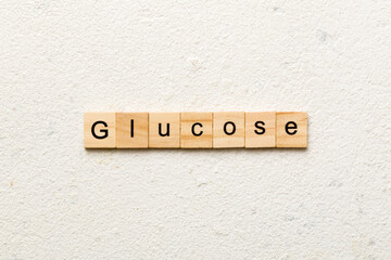 GLUCOSE word written on wood block. GLUCOSE text on cement table for your desing, concept