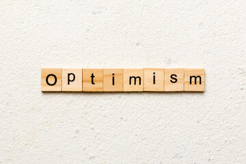 Optimism word written on wood block. Optimism text on cement table for your desing, concept