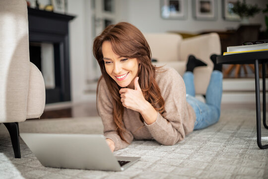 Happy woman with laptop relaxing at home