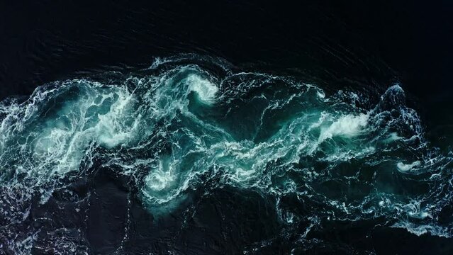 Abstract background. The waves of the sea water meet with underwater pointed rocks, forming whirlpools. Whirlpools in the area of the Norway