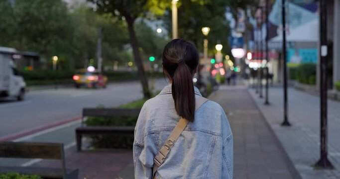 Woman walk in the city in the evening