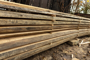 Piled lumber near a lumber mill. Lumber and wood slice. Stacked lumber. Folded wood.Closeup wooden board
