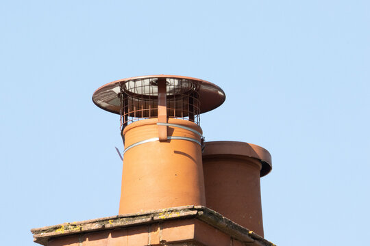 a pair of traditional English chimney pots against a bright blue sky