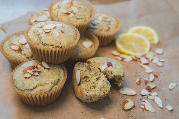 Closeup shot of poppy seed muffins with almonds, with sliced lemon in the background