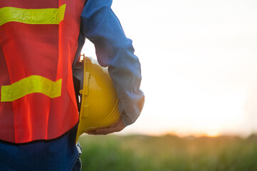 Close up hand holding white helmet hard hat Engineering concept, Technician holding hard hat safety hard hat sunlight background