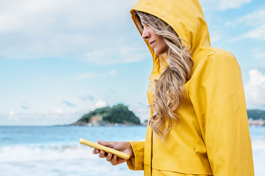 Woman browsing smartphone on beach