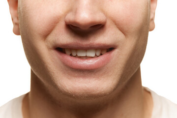 Close-up cropped image of man's face, nose lips and teeth isolated over white studio background. Dental care. Concept of men's health