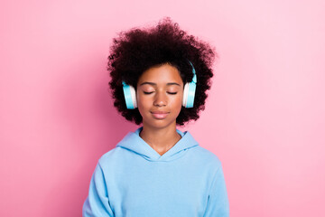 Photo portrait of cute school girl closed eyes listen calm music meditate dressed stylish blue clothes isolated on pink color background