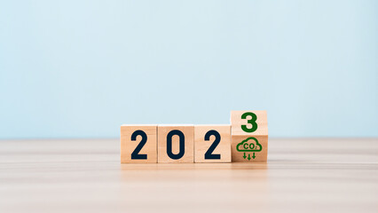 wooden cubes with net zero icon in 2023 on blue sky background. in Net zero greenhouse gas...