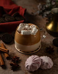 Coffee with marshmallows with spices, cinnamon, cookie, star anise on brown table