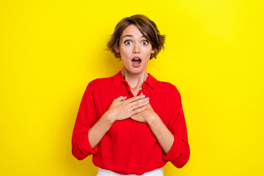 Photo of adorable gorgeous nice girl with bob hairstyle wear red shirt hands on chest open mouth isolated on yellow color background