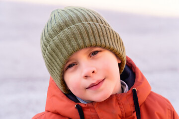 Smiling boy in a knitted hat in autumn
