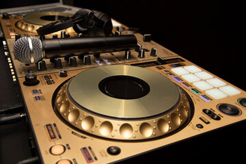 Dj table next to dj implements such as microphone, headphones and laptop in the background. Concept...