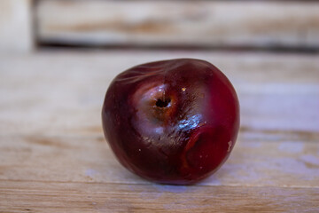 Rotten plum on wooden table