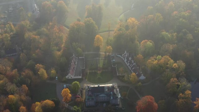 Drone view of autumn-colored trees next to Brantz castle in the Pueckler Park