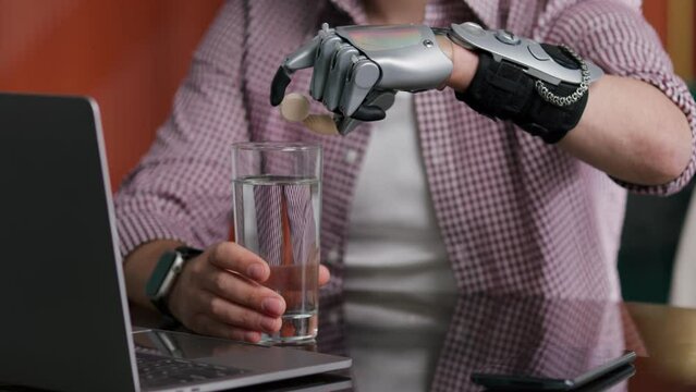 Cropped shot of man with artificial bionic arm putting pill in glass of water