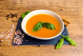 Pumpkin traditional soup with creamy  texture on gray textured background . Top view 
