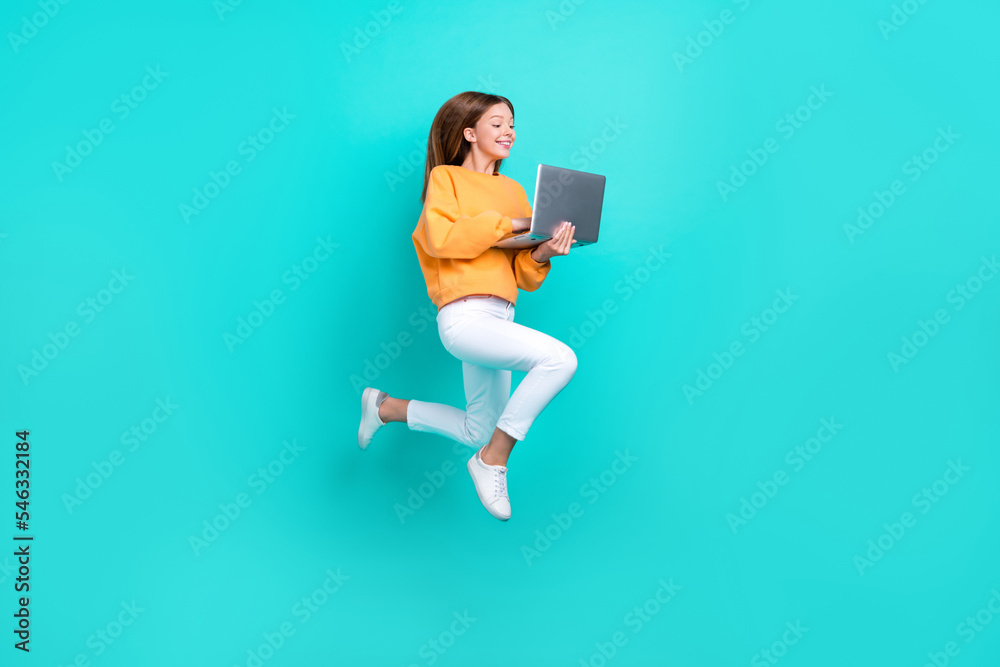 Sticker full length photo of excited funny schoolgirl wear orange sweatshirt typing modern device jumping hi