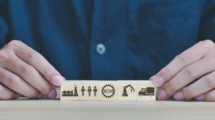 Man's hand holding wooden cubes with business strategy-related icons on them