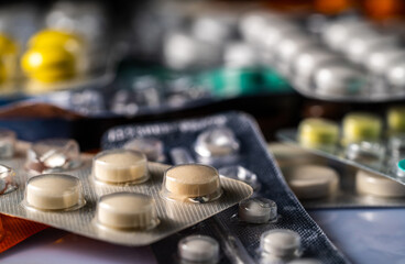 Pharmaceutical various tablets packed in silver blister packs. Close up of white and green pills in package. Bunch of drugs. Vitamins, antibiotics, painkillers. Medicines for treatment of viruses.