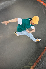 Graphic top view of young man dancing hip hop outdoors and wearing colorful street style clothes