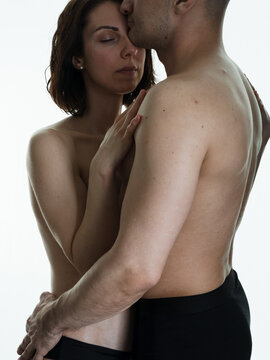 Beautiful passionate naked couple in love. A man and a woman in each other's arms. Photo on a white background.