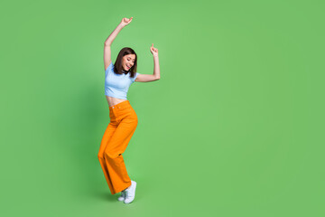 Full length portrait of pretty positive person enjoy dancing empty space isolated on green color background