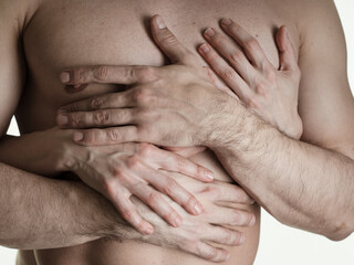 A man in a woman's arms. Women's hands on a man's chest. Close-up on a white background. Photo without a face.