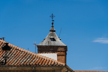 Old tower crowned with a spire in the old town of Avila, Spain. View against blue sky