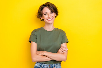 Portrait of cute confident satisfied woman with bob hairdo dressed khaki t-shirt standing arms folded isolated on yellow color background