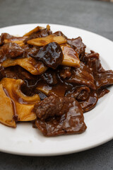 Close up of a dish of beef with mushrooms and bamboo from oriental cuisine.