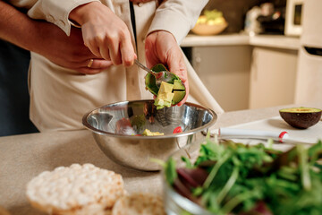 Lovely family couple preparing vegetable vegan salad together in kitchen. Healthy food and diet concept lifestyle. Cook at home