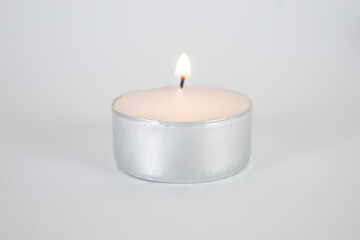 Fototapeta na wymiar Burning candle close up on a white background 