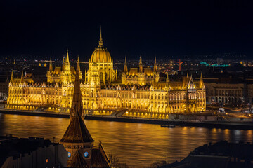 Obraz premium Illuminated Hungarian Parliament Building and Szilágyi Dezső Square Reformed Church. Budapest, Hungary, Eastern Europe.